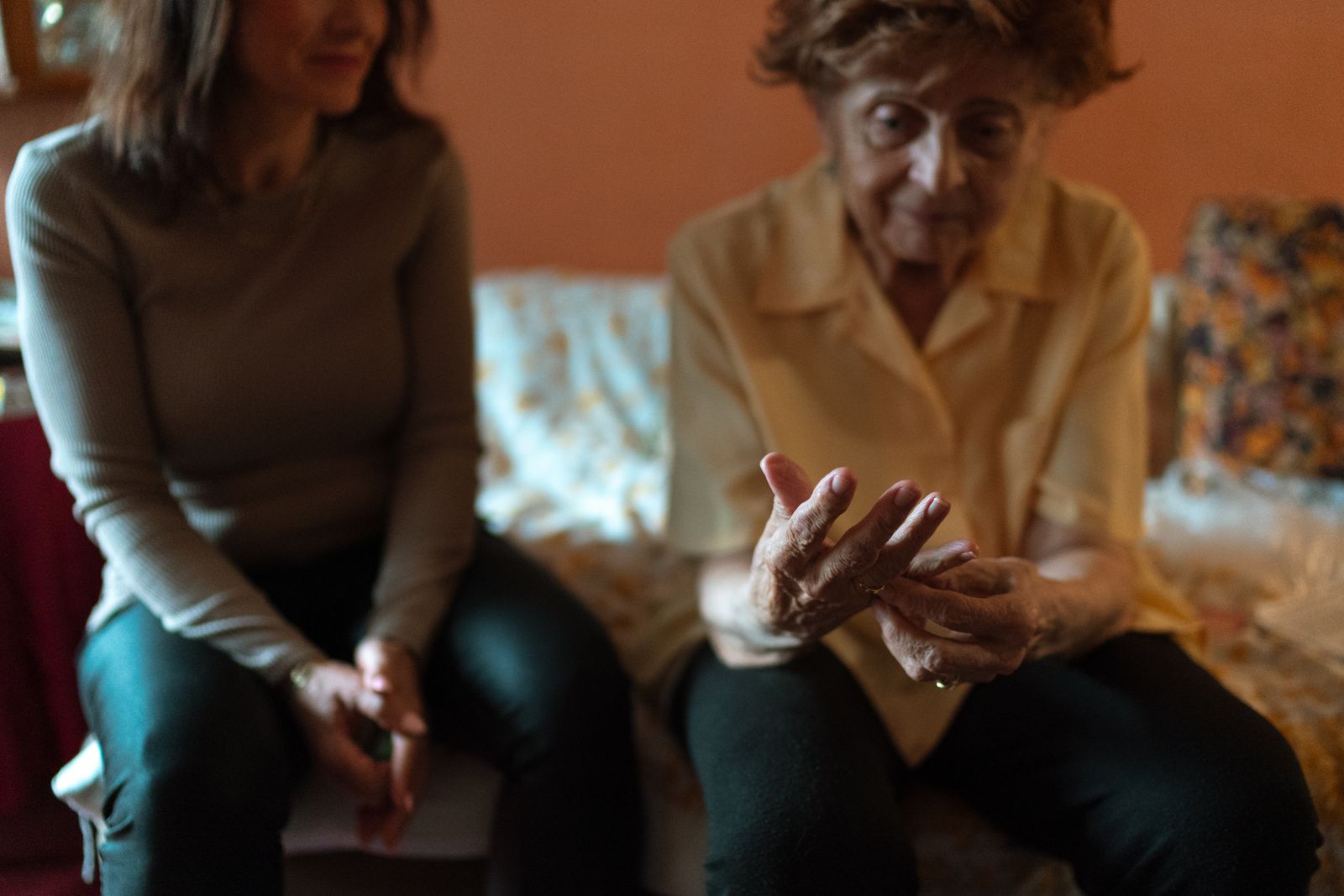 A quieter moment of companionship between an older adult and a younger caregiver at home
