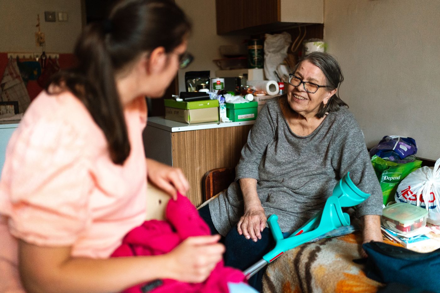 An older adult and a caregiver sharing a warm conversation at home